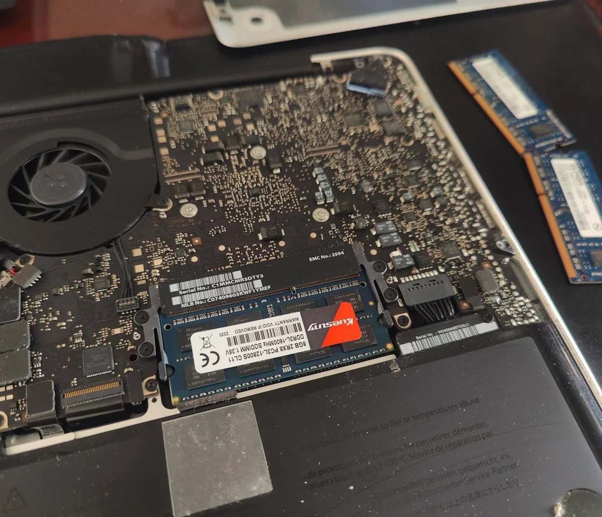 MacBook abierta con los módulos de memoria RAM visibles durante un trabajo de ZOITECH